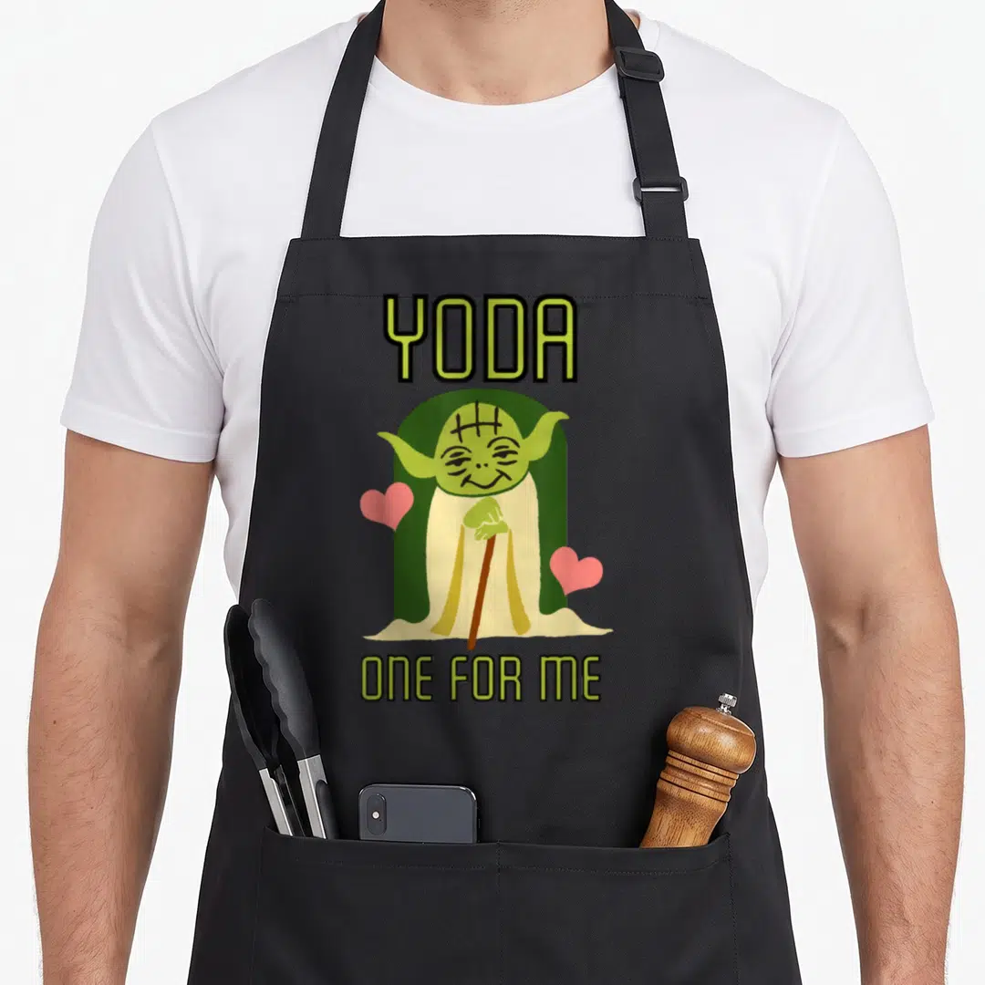 Yoda valentine's day apron - Cartoon Yoda holding a cane between two pink hearts with text YODA and ONE FOR ME — shown on a black cotton canvas apron against a white background