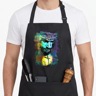 Christ religious cross apron - Watercolor Jesus portrait with crown of thorns and three crosses in blue purple green — shown on a black cotton canvas apron against a white background