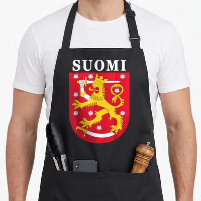 Finnish finland apron - SUOMI text above red shield with yellow lion holding sword and white flowers — shown on a black cotton canvas apron against a white background