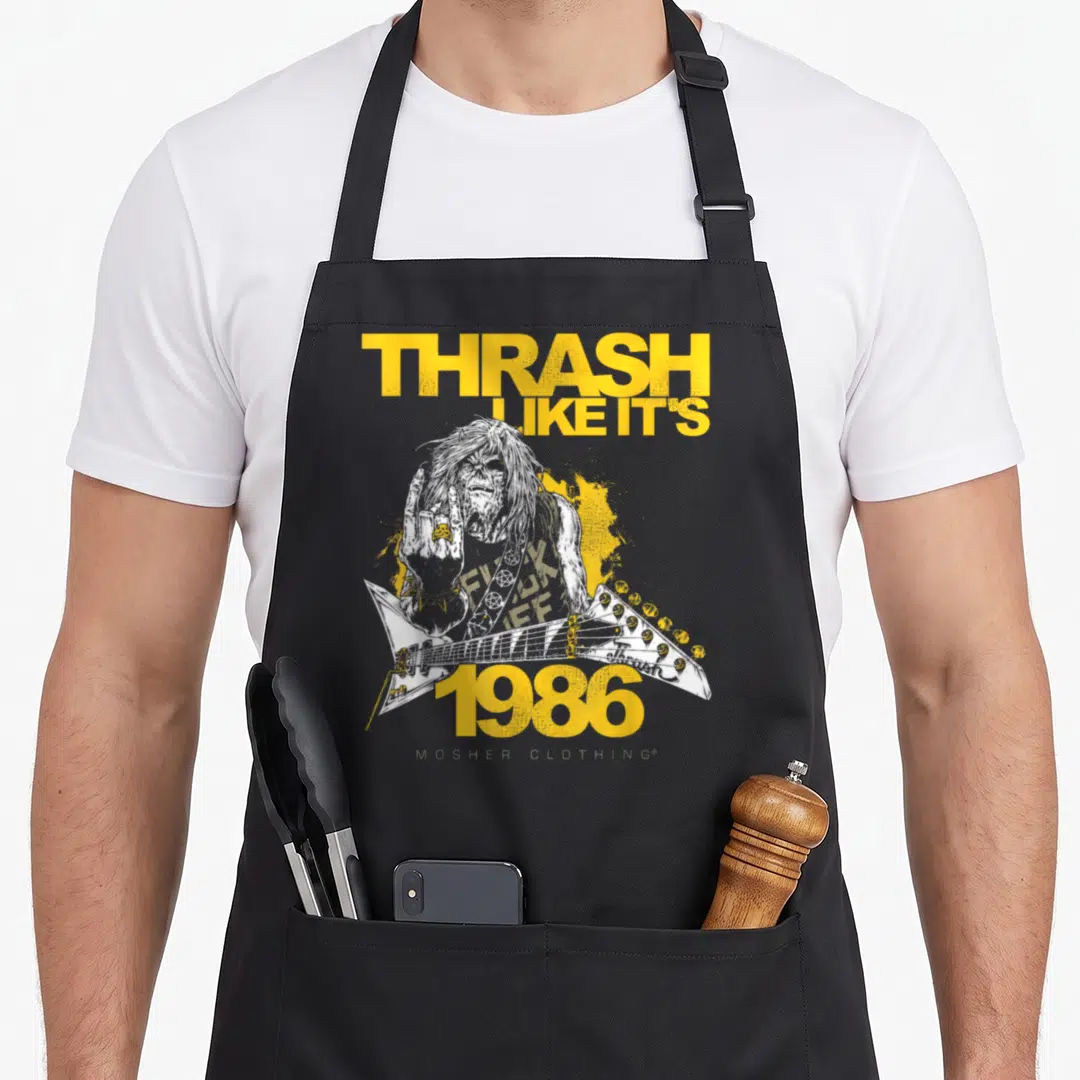 Thrash a's aprons - Distressed zombie guitarist with THRASH LIKE IT'S 1986 text and yellow splatter — shown on a black cotton canvas apron against a white background