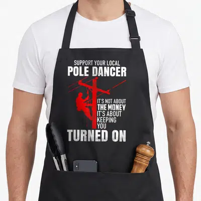 Support pole apron - Red lineman silhouette climbing a utility pole with white distressed text — shown on a black cotton canvas apron against a white background