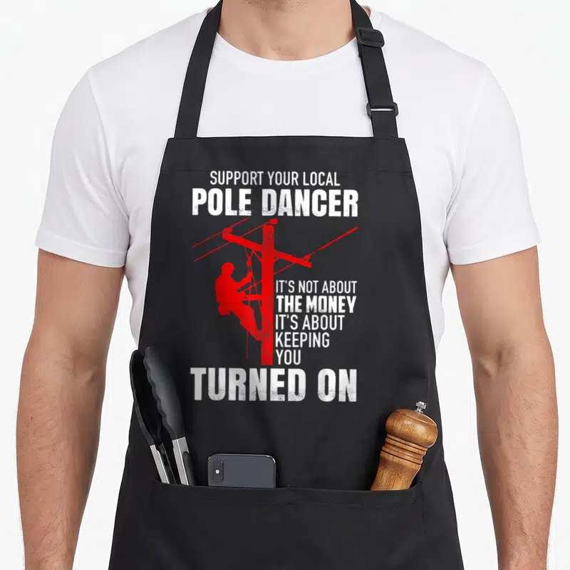 Support pole apron - Red lineman silhouette climbing a utility pole with white distressed text — shown on a black cotton canvas apron against a white background