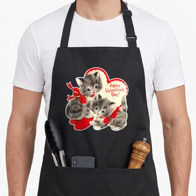 Cat kitten valentine's day apron - Two grey kittens with red bows sitting inside a red heart with Happy Valentine's Day — shown on a black cotton canvas apron against a white background