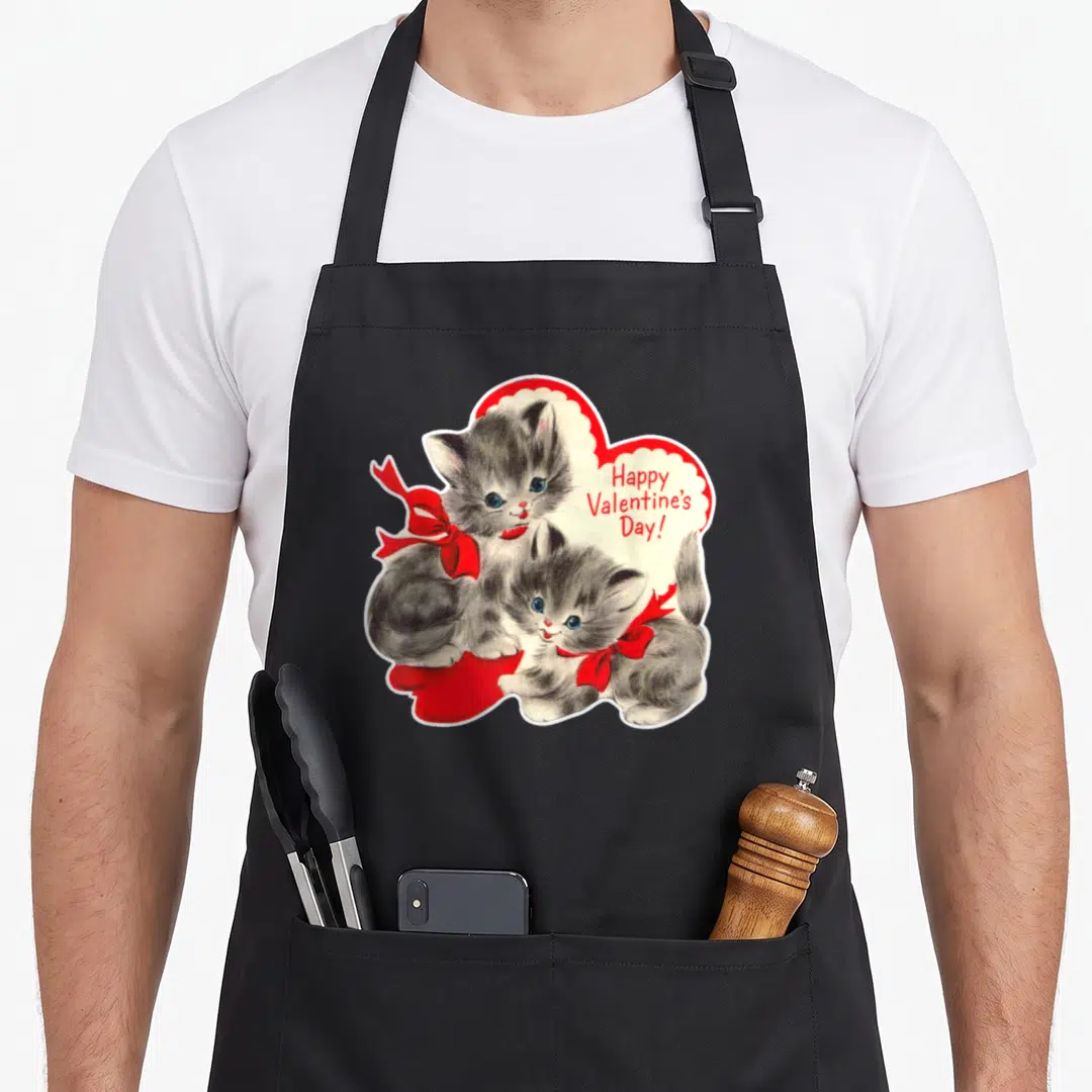 Cat kitten valentine's day apron - Two grey kittens with red bows sitting inside a red heart with Happy Valentine's Day — shown on a black cotton canvas apron against a white background