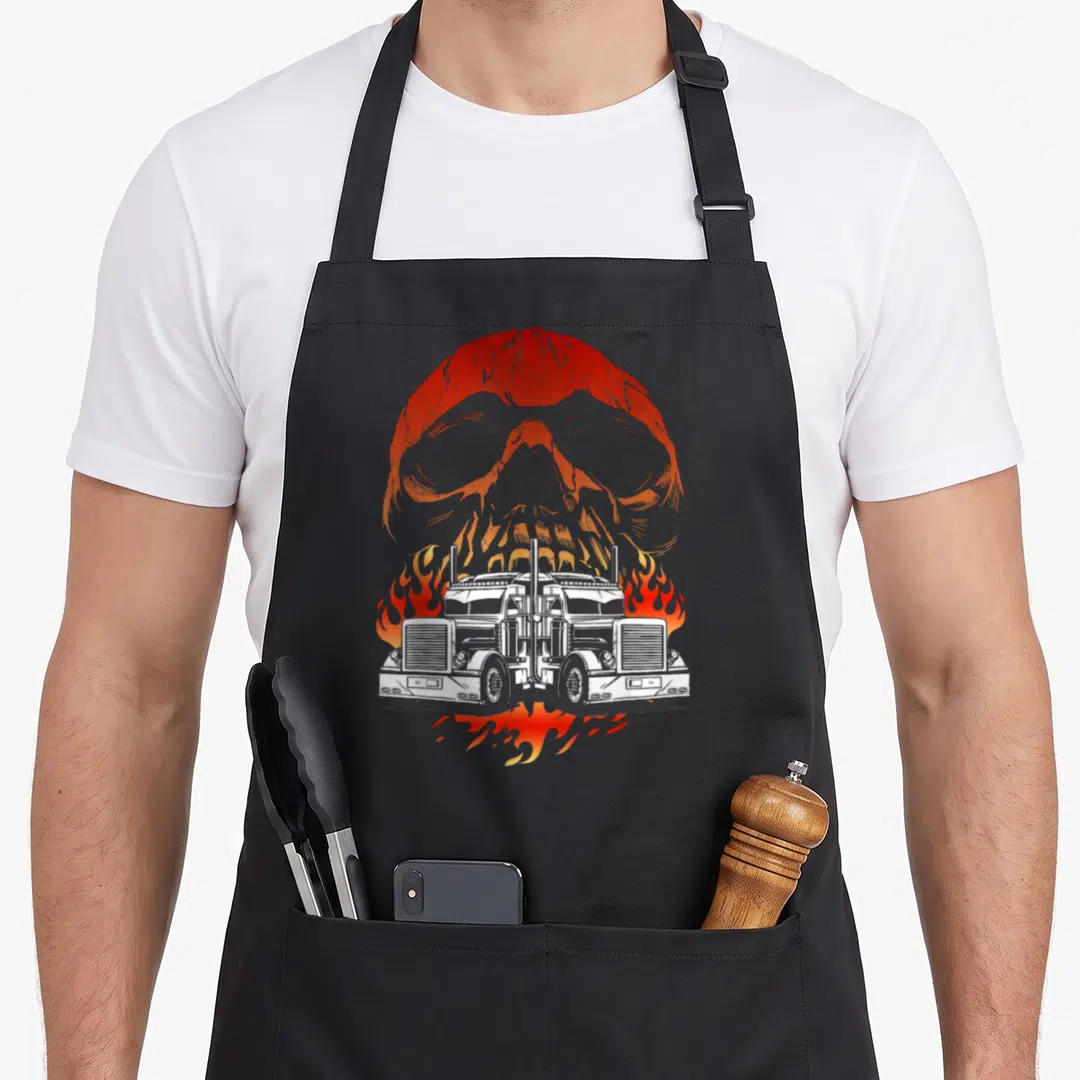 Trailer truckin semi truck apron - Two white semi-trucks facing forward surrounded by orange flames with a large orange — shown on a black cotton canvas apron against a white background