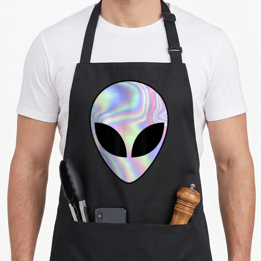 Alien colorful aprons - Holographic alien head in blue pink purple black with two front pockets — shown on a black cotton canvas apron against a white background