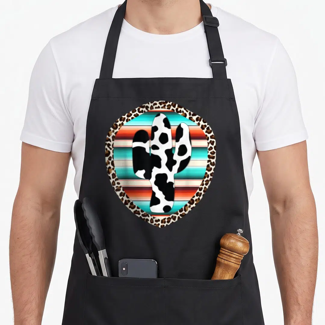 Serape leopard print apron - Cow print cactus on striped background inside leopard shield border — shown on a black cotton canvas apron against a white background