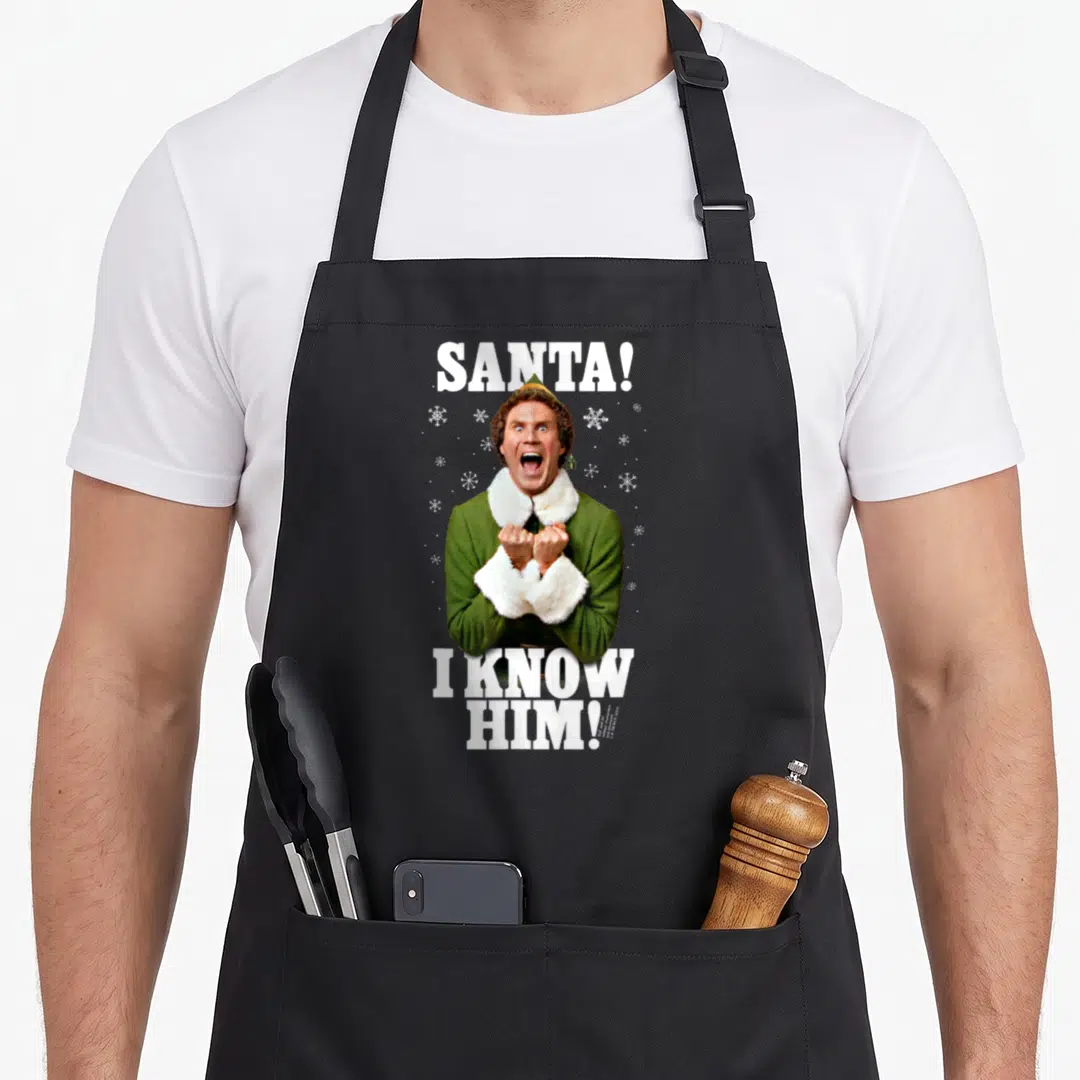Santa elf apron - Photo of elf in green coat with white snowflakes and text Santa! I Know Him! — shown on a black cotton canvas apron against a white background
