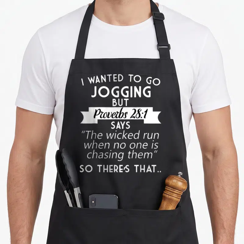 Proverb jogging apron - White typography reading I wanted to go jogging but Proverbs 28:1 says the wicked run when no — shown on a black cotton canvas apron against a white background