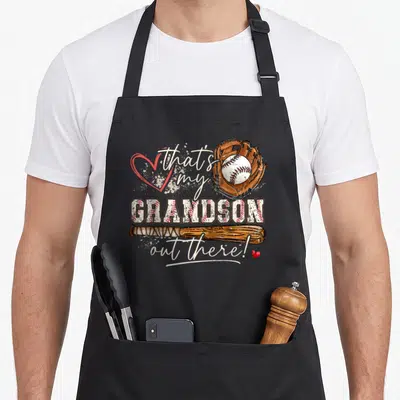Grandson mother's day aprons - Baseball glove, bat, and text that's my GRANDSON out there with red hearts — shown on a black cotton canvas apron against a white background
