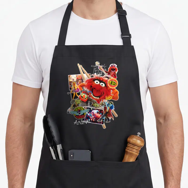 Teeth animal apron - Collage of Animal and Dr Teeth with crossed drumsticks and logos — shown on a black cotton canvas apron against a white background