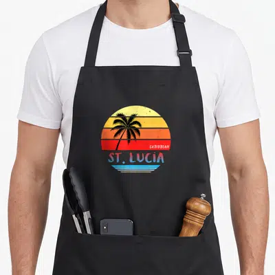 Lucia st apron - Retro sunset with black palm tree and ST. LUCIA text in blue and white bands — shown on a black cotton canvas apron against a white background