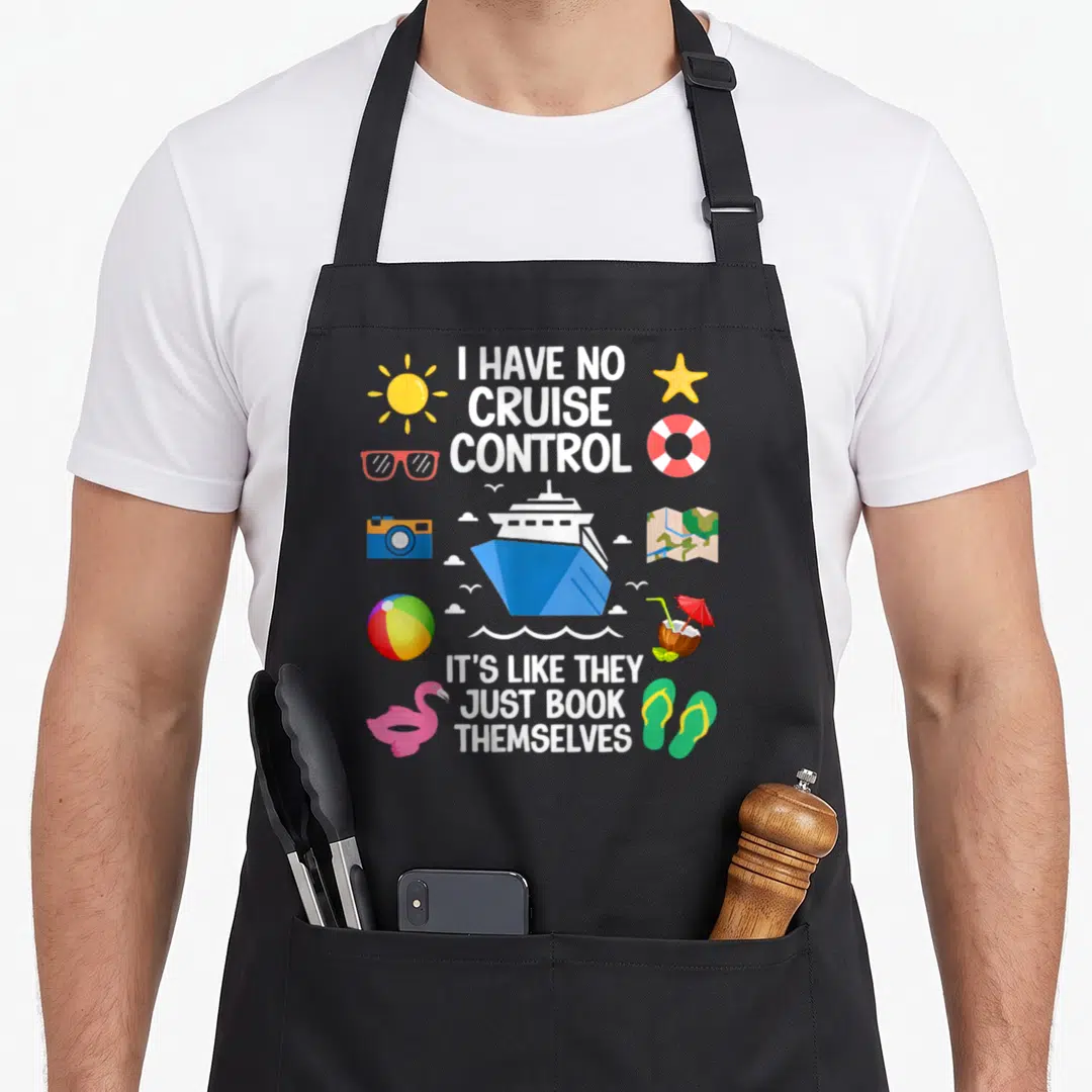 Control crazy cruise apron - Cartoon cruise ship with vacation icons and text I HAVE NO CRUISE CONTROL IT'S LIKE THEY — shown on a black cotton canvas apron against a white background