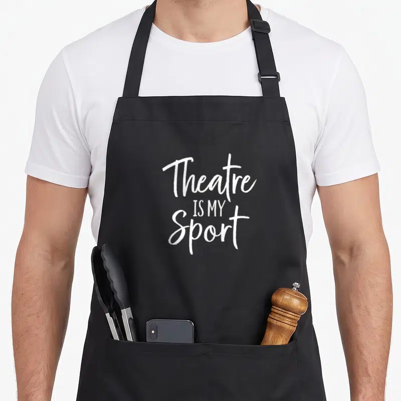 Sport theatre apron - White stacked text reading Theatre IS MY Sport on grey background — shown on a black cotton canvas apron against a white background
