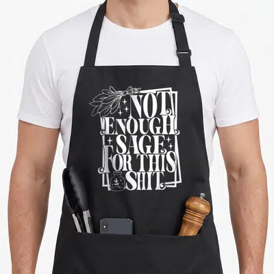 Enough sage apron - White stacked text Not Enough Sage For This Shit with sage bundle and jar illustration — shown on a black cotton canvas apron against a white background