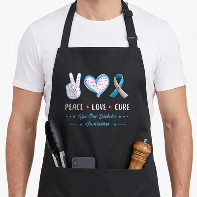 Peace diabete awareness apron - Peace sign heart ribbon with PEACE LOVE CURE text and red drops in blue white red grey — shown on a black cotton canvas apron against a white background