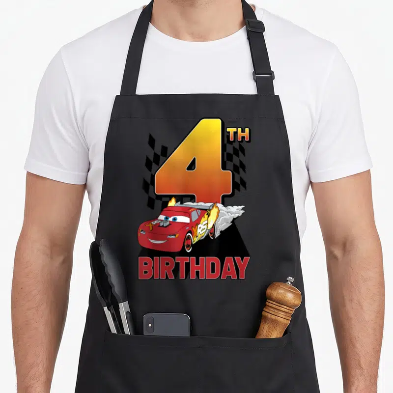 4th car apron - Large number 4 with red race car, checkered flag, and BIRTHDAY text in cartoon style — shown on a black cotton canvas apron against a white background