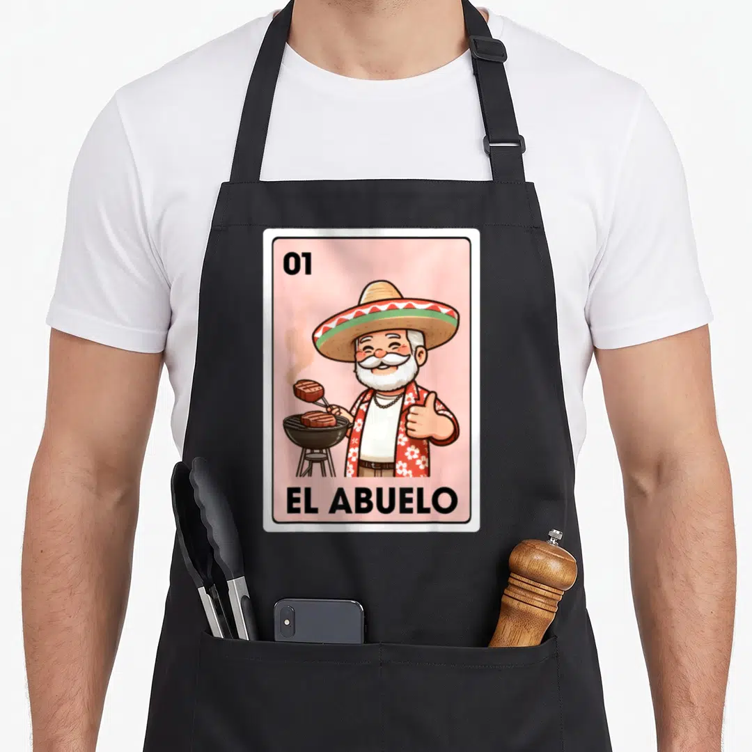Grandpa mexican apron - Cartoon grandfather grilling steak on pink background with text 01 EL ABUELO — shown on a black cotton canvas apron against a white background