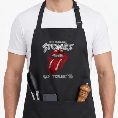 Retro tour rolling stones apron - Red and white distressed lips with arched Rolling Stones text and U.S. Tour '78 below — shown on a black cotton canvas apron against a white background