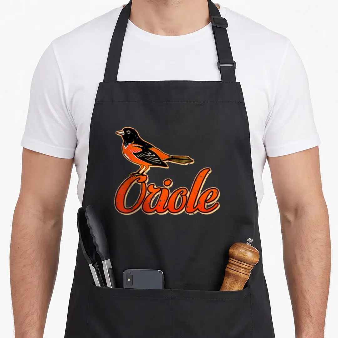 Oriole bird apron - Cartoon bird perched on curved orange text reading Oriole in black and white — shown on a black cotton canvas apron against a white background
