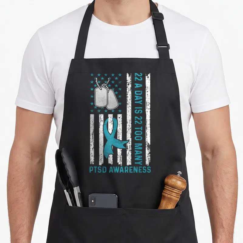 Many veterans apron - Distressed flag with dog tags, teal ribbon, and 22 A Day is 22 Too Many text — shown on a black cotton canvas apron against a white background