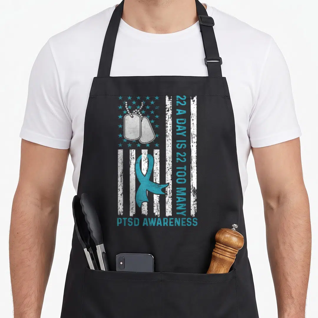 Many veterans apron - Distressed flag with dog tags, teal ribbon, and 22 A Day is 22 Too Many text — shown on a black cotton canvas apron against a white background