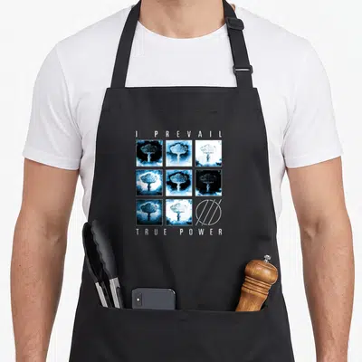 Prevail novelty apron - I Prevail True Power text with mushroom cloud grid and geometric circle logo in blue and white — shown on a black cotton canvas apron against a white background