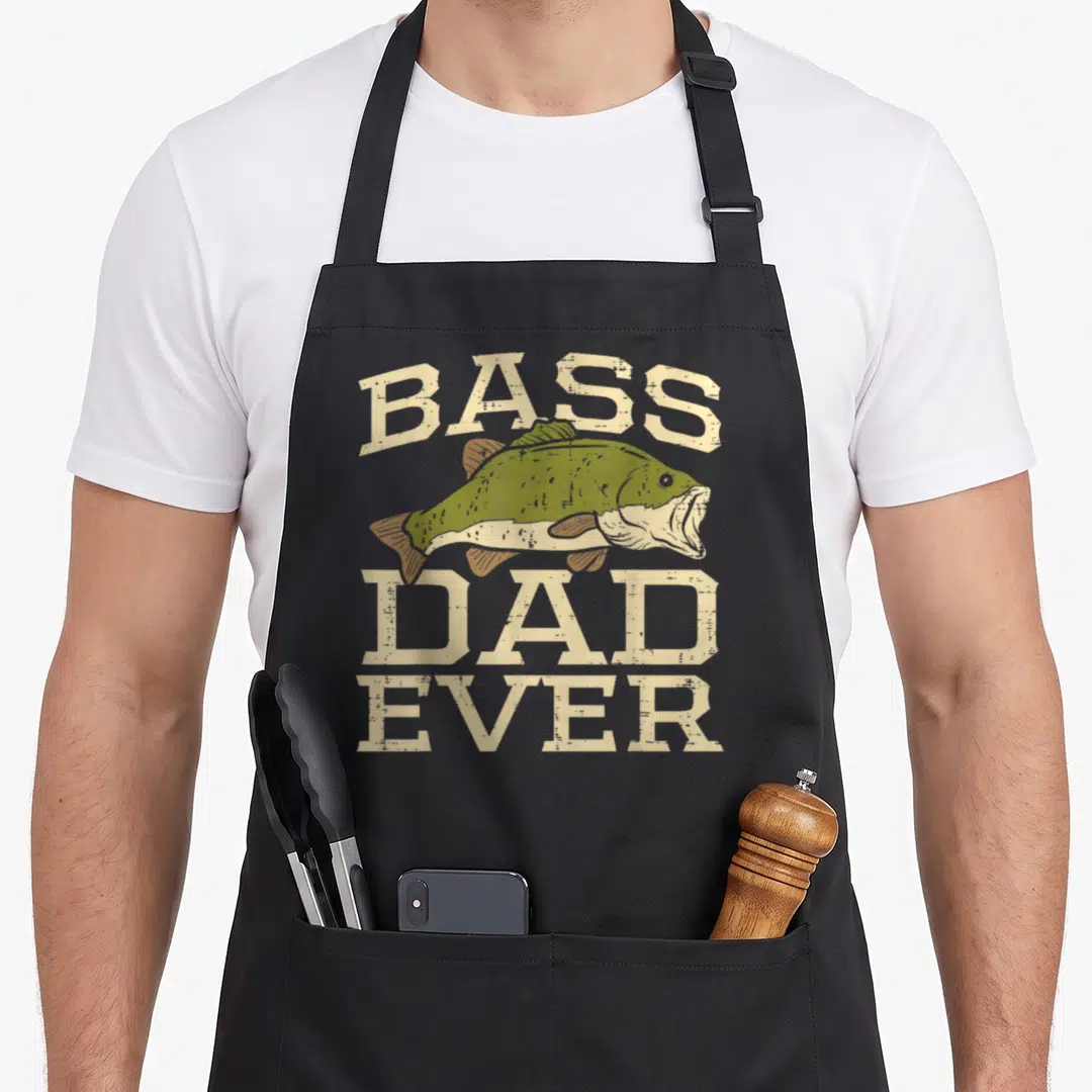 Bass father day apron - Distressed beige text reading Bass Dad Ever around an olive green bass fish illustration — shown on a black cotton canvas apron against a white background