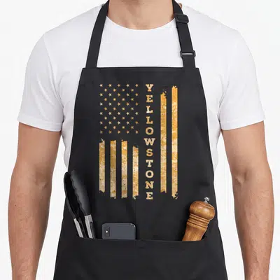 Funny park national apron - Vertical yellow distressed flag with text reading YELLOWSTONE replacing stripes — shown on a black cotton canvas apron against a white background