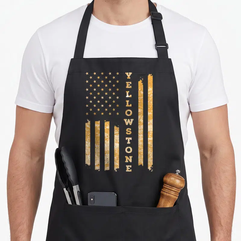 Funny park national apron - Vertical yellow distressed flag with text reading YELLOWSTONE replacing stripes — shown on a black cotton canvas apron against a white background