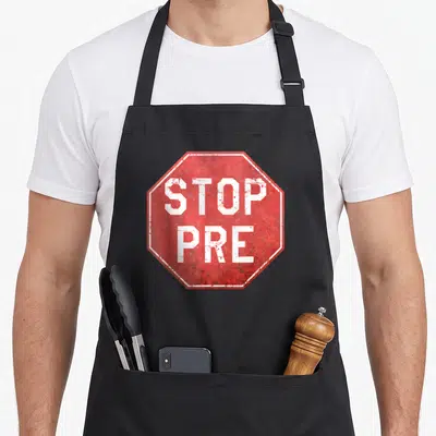 Stop marathon apron - Red octagonal stop sign with white border and distressed text reading STOP PRE — shown on a black cotton canvas apron against a white background