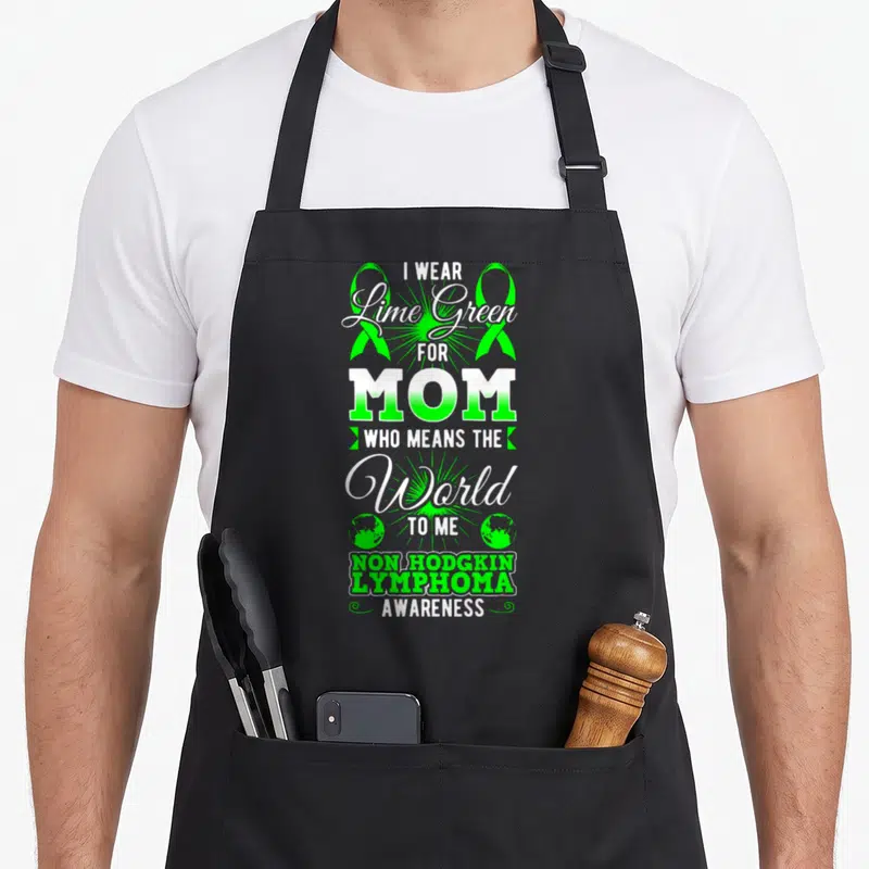 Mean lime green apron - Stacked white and lime text with two ribbons and globes honoring Non-Hodgkin Lymphoma mom — shown on a black cotton canvas apron against a white background
