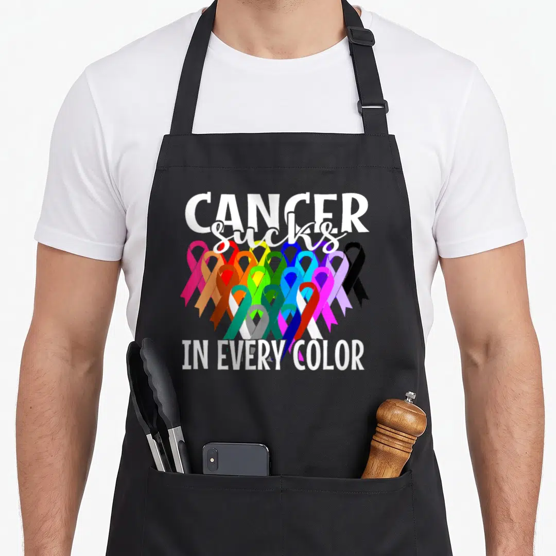 Suck liver cancer awareness apron - Multicolored awareness ribbons with white text reading CANCER sucks IN EVERY COLOR — shown on a black cotton canvas apron against a white background