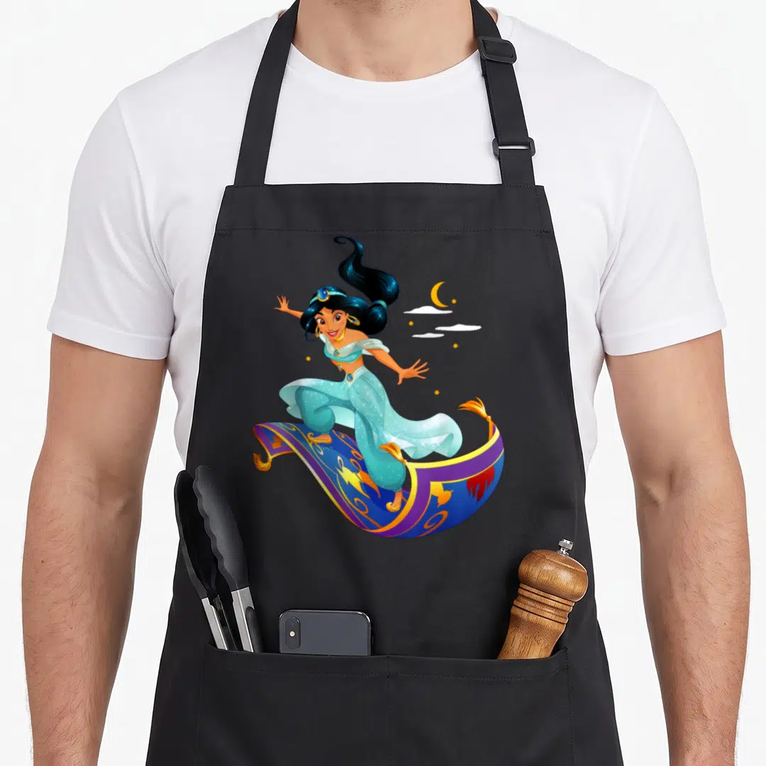 Princess magic apron - Cartoon woman standing on flying magic carpet with blue purple gold crescent moon clouds — shown on a black cotton canvas apron against a white background