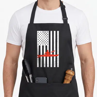 Kayaker american flag apron - Red kayaker silhouette over vertical white American flag pattern with distressed texture — shown on a black cotton canvas apron against a white background