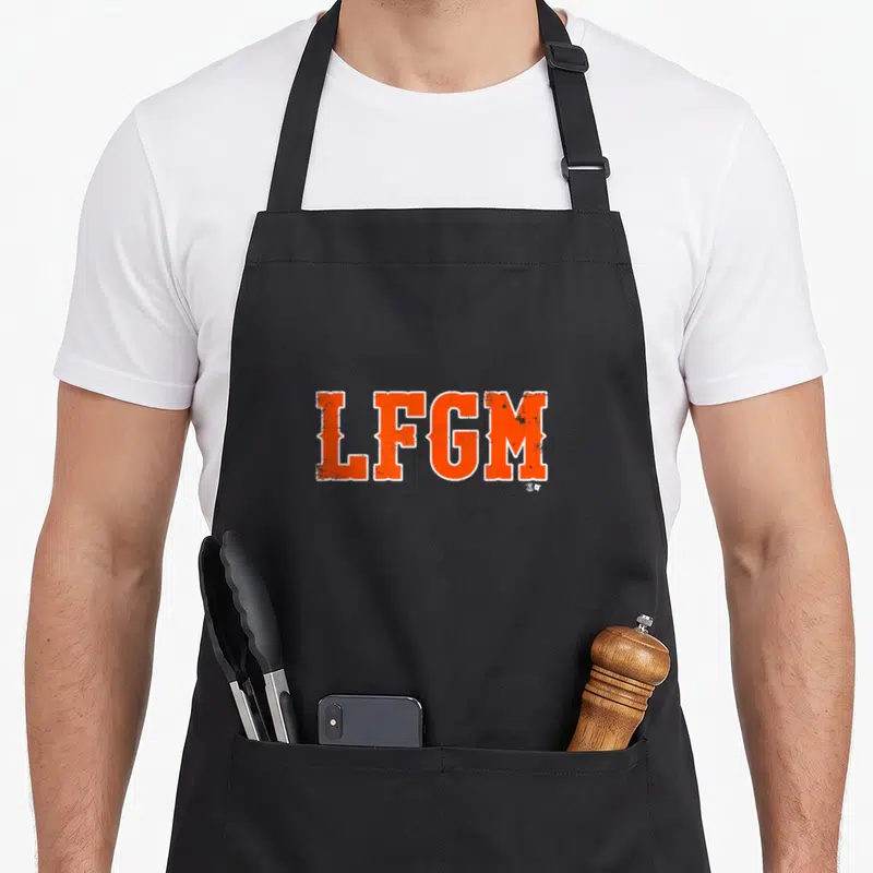 Pete baseball apron - Orange LFGM text with white outline in distressed style on black fabric — shown on a black cotton canvas apron against a white background