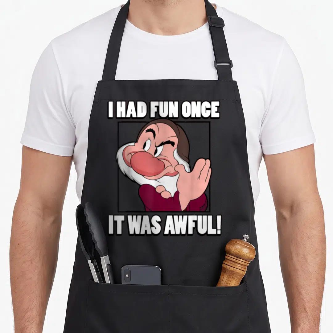 Awful snow white apron - Grumpy cartoon character in black frame with text I HAD FUN ONCE IT WAS AWFUL — shown on a black cotton canvas apron against a white background