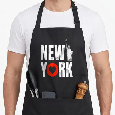 Statue liberty souvenir new york apron - New York text with red heart and white statue silhouette — shown on a black cotton canvas apron against a white background