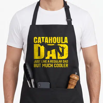 Parent leopard apron - Yellow distressed CATAHOULA DAD text with dog silhouette — shown on a black cotton canvas apron against a white background