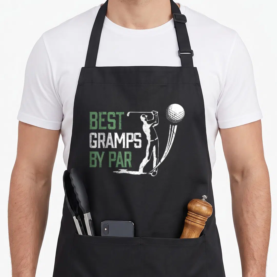 Gramp par father day apron - Stacked BEST GRAMPS BY PAR text next to white golfer swinging at a ball — shown on a black cotton canvas apron against a white background