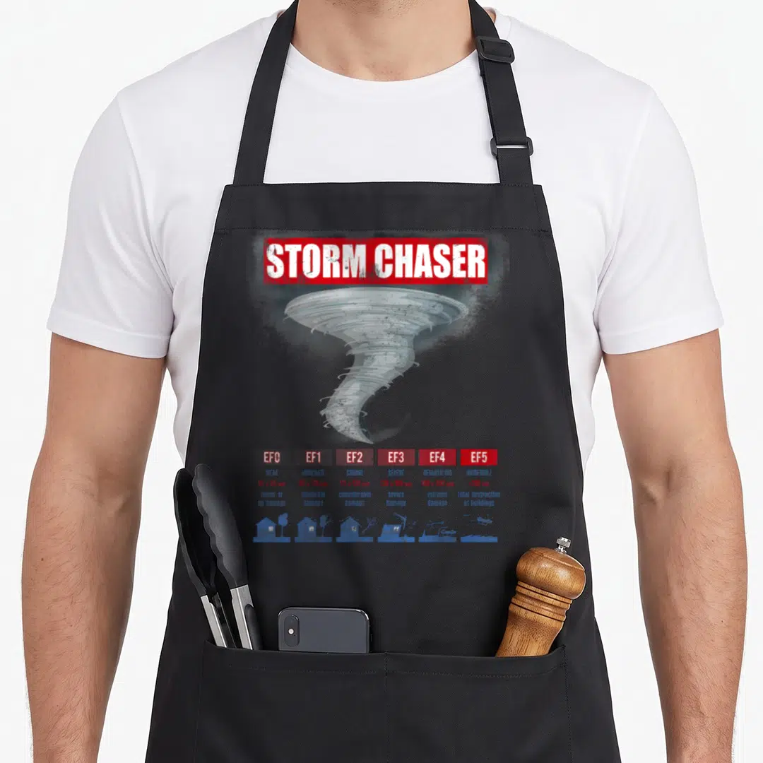 Chaser storm chasing apron - Tornado graphic above EF0-EF5 wind speed and damage chart with house icons — shown on a black cotton canvas apron against a white background