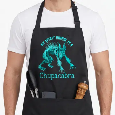 Chupacabra animal apron - Cyan chupacabra creature with MY SPIRIT ANIMAL IS A text arched above — shown on a black cotton canvas apron against a white background