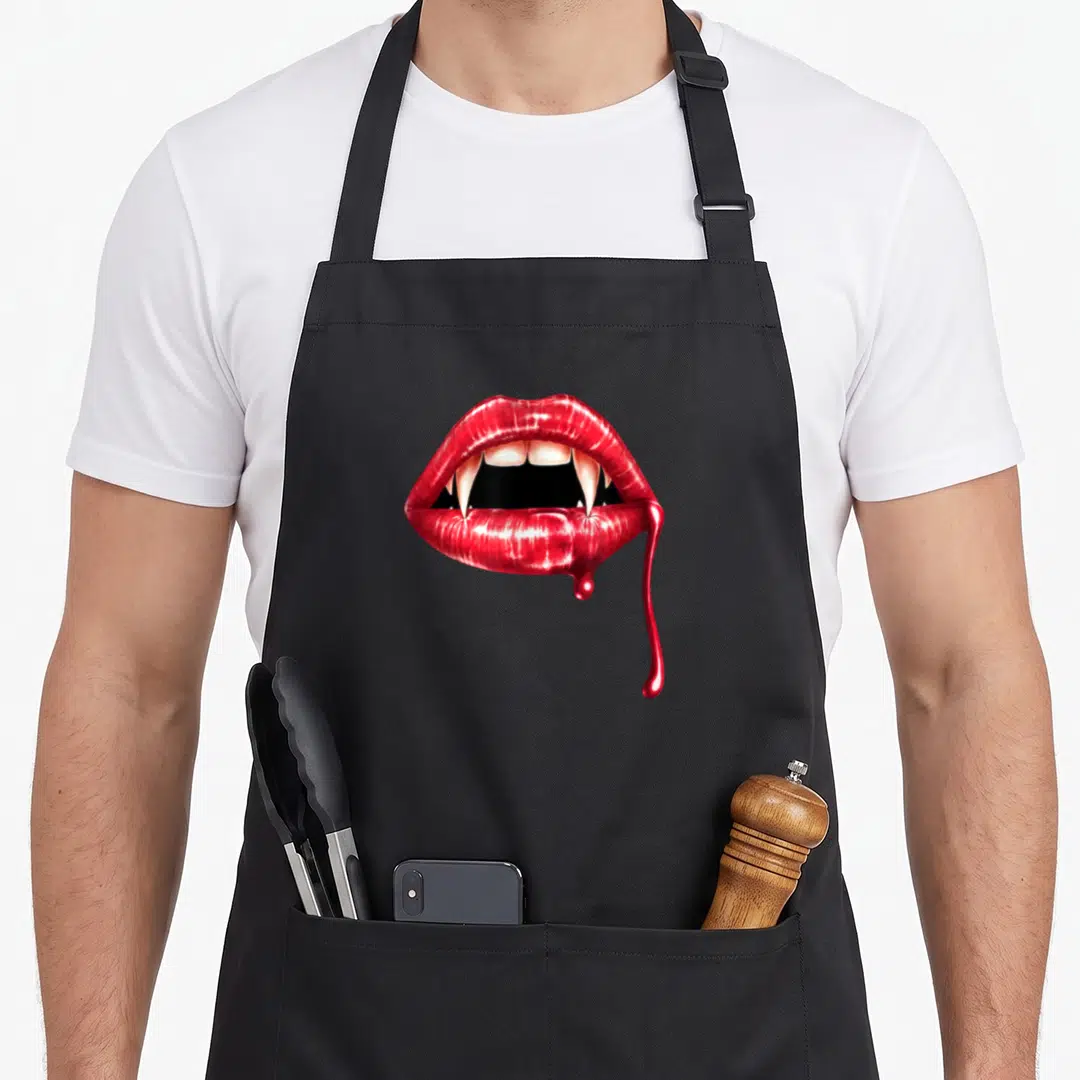 Sour halloween apron - Realistic red lips with vampire fangs and dripping blood detail — shown on a black cotton canvas apron against a white background
