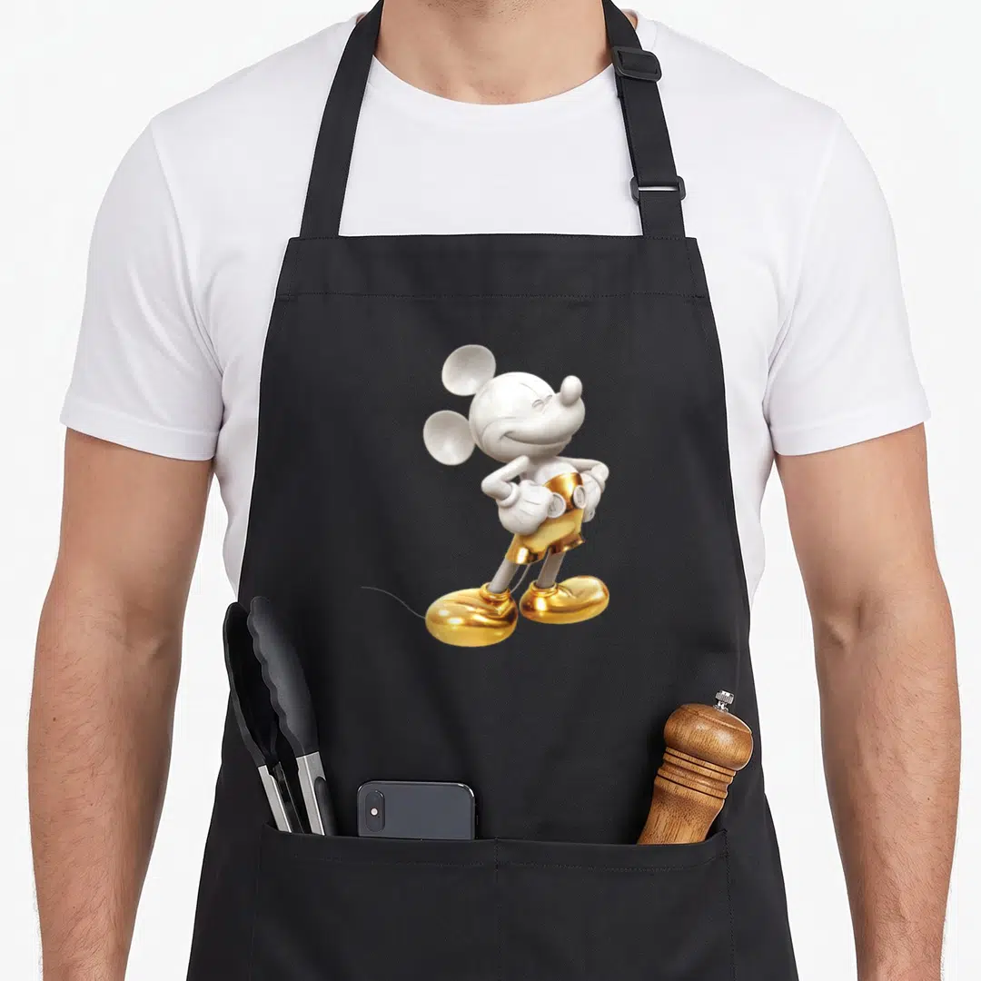 Pose crazy mouse man apron - White and gold Mickey Mouse figure standing with hands on hips — shown on a black cotton canvas apron against a white background