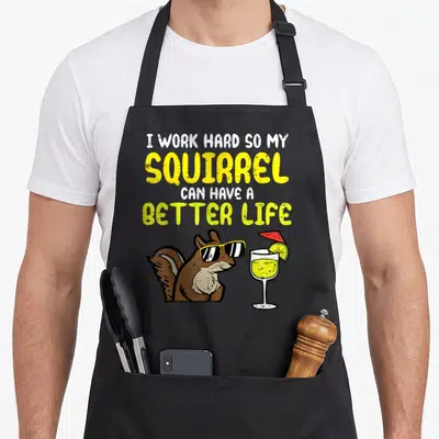Hard squirrel aprons - Cartoon brown squirrel wearing yellow sunglasses beside a cocktail glass with red umbrella — shown on a black cotton canvas apron against a white background