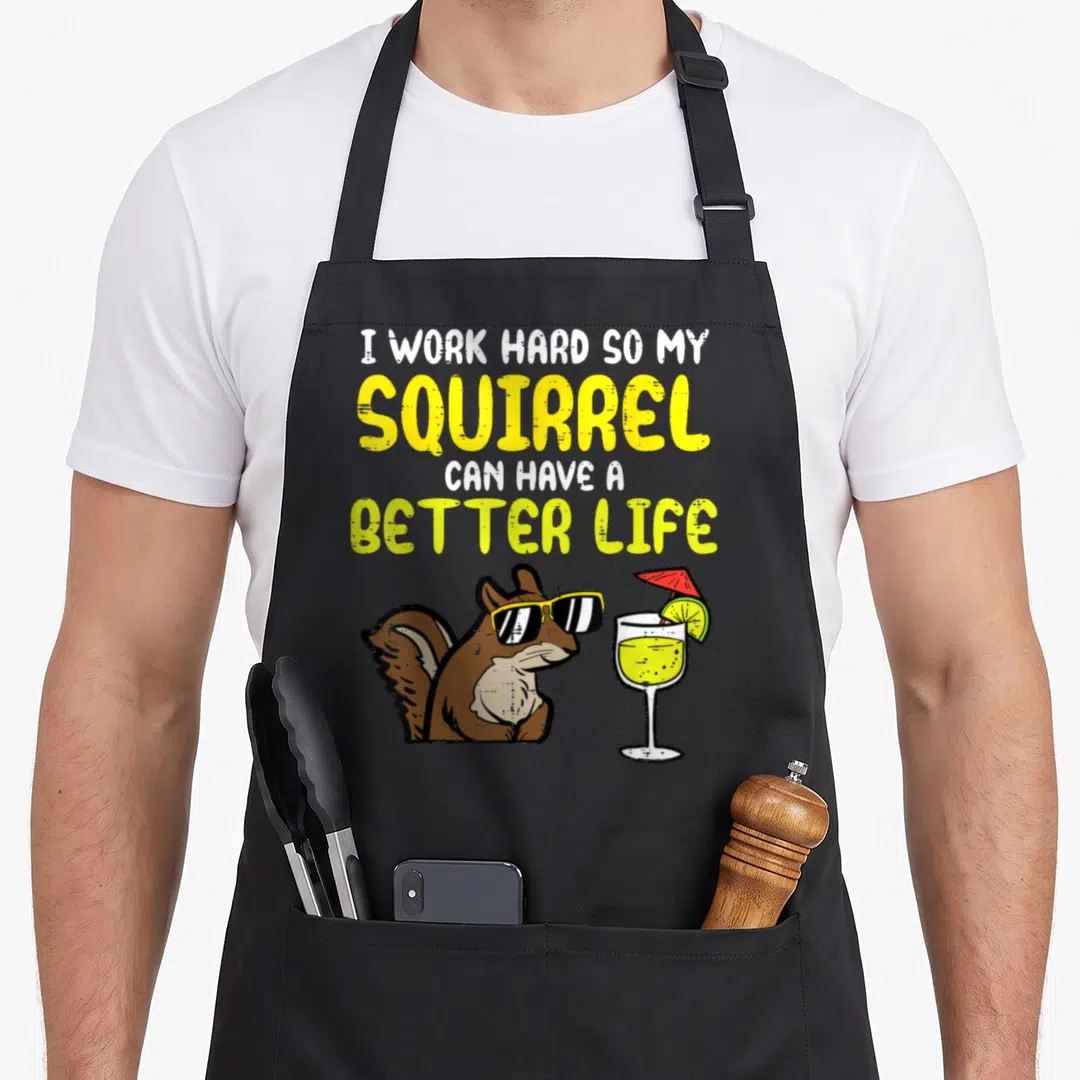 Hard squirrel aprons - Cartoon brown squirrel wearing yellow sunglasses beside a cocktail glass with red umbrella — shown on a black cotton canvas apron against a white background