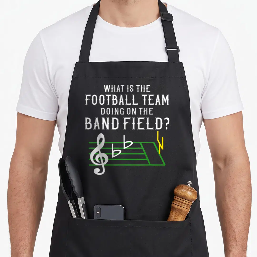 Marching football team aprons - White text asking about football team on band field above green staff and yellow goal — shown on a black cotton canvas apron against a white background