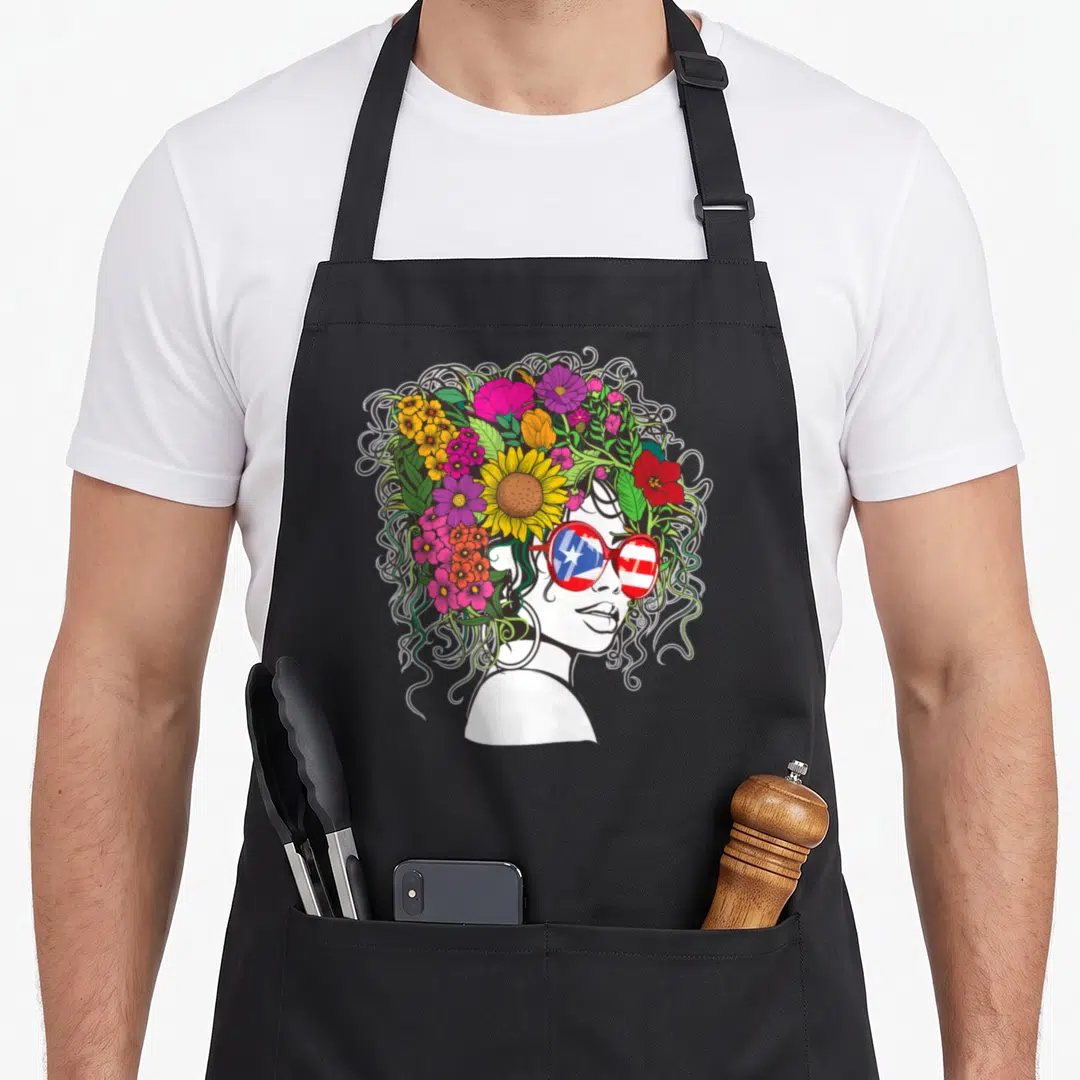 Flower hair apron - Woman profile with colorful flower afro and sunglasses showing Puerto Rican flag pattern — shown on a black cotton canvas apron against a white background
