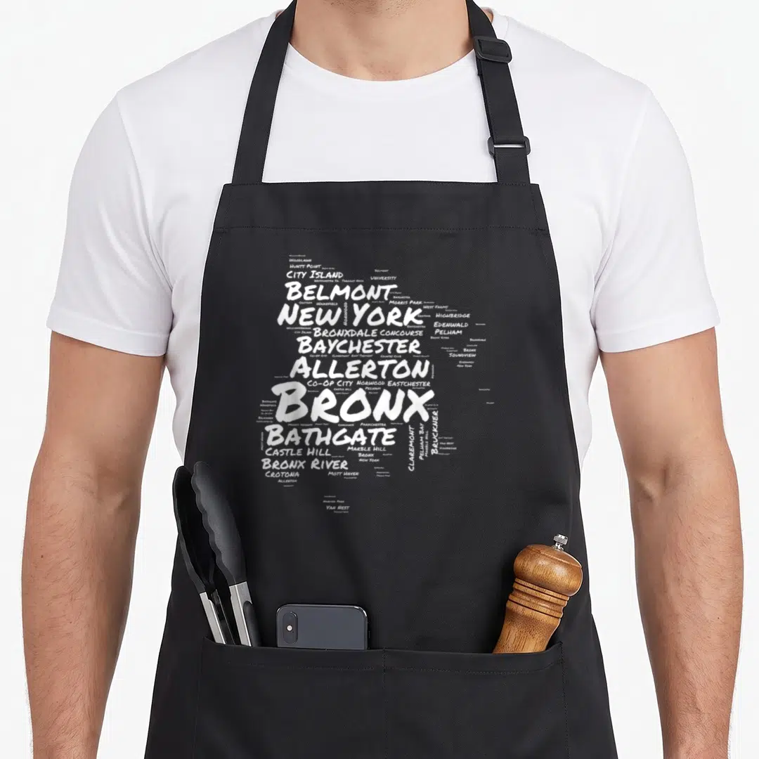 Neighborhood new york apron - White word cloud of Bronx neighborhoods like Belmont, Bathgate, and Pelham Bay on canvas — shown on a black cotton canvas apron against a white background
