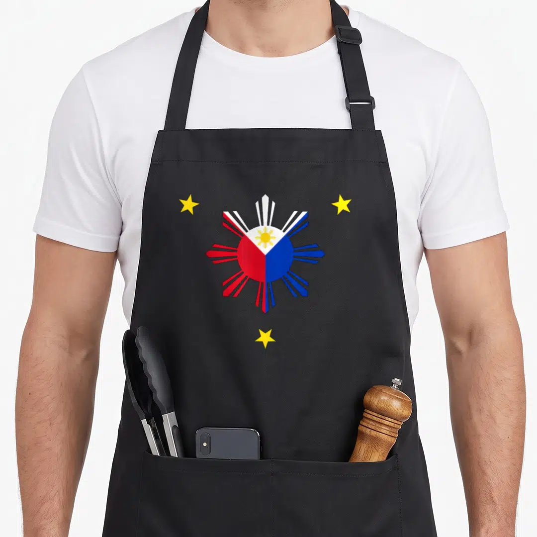 Philippine pride apron - Minimalist sun emblem with three yellow stars in red, blue, white, yellow on black bib — shown on a black cotton canvas apron against a white background
